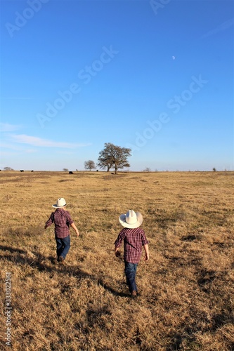 Two Little Cowboys Heading Out Across A Pasture in South Central Oklahoma to Check on the Calves