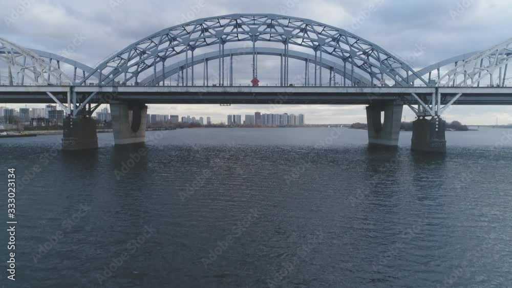 Darnitsky bridge over the Dnieper River. Ukraine city Kiev. Video from the drone. The rise of the camera from water to the sky to the general plan Darnitsky bridge over the Dnieper River. Ukraine city Kiev. Video from the drone. The rise of the camera from water to the sky to the general plan