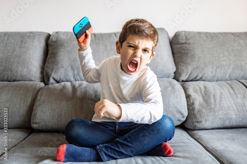 Fotografia Excited boy playing video games at home
