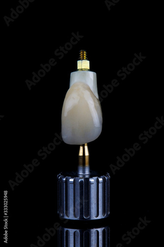 dental crown of anterior incisor made of ceramic and zircon, on black glass
