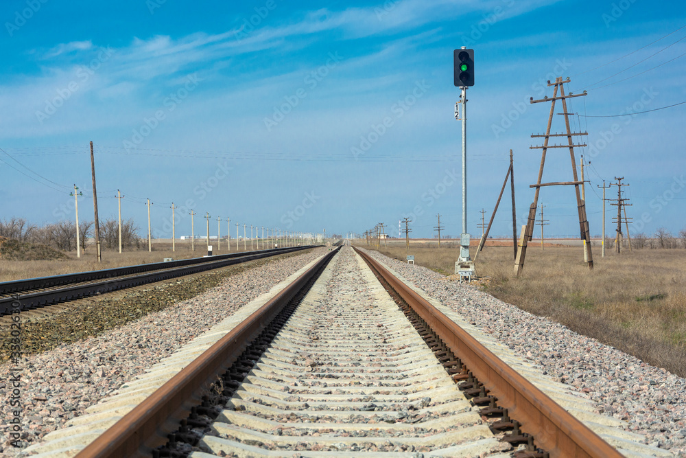 Obraz premium Rails close-up, the railway goes to the horizon, the green traffic light is on, the path is clear. The concept of free movement, freedom