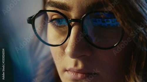 Close up of attractive female office worker working late at office or home , freelancer girl using laptop browsing internet. Slow motion.