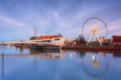 Gdansk with beautiful ferris wheel over Motlawa river at sunset, Poland.