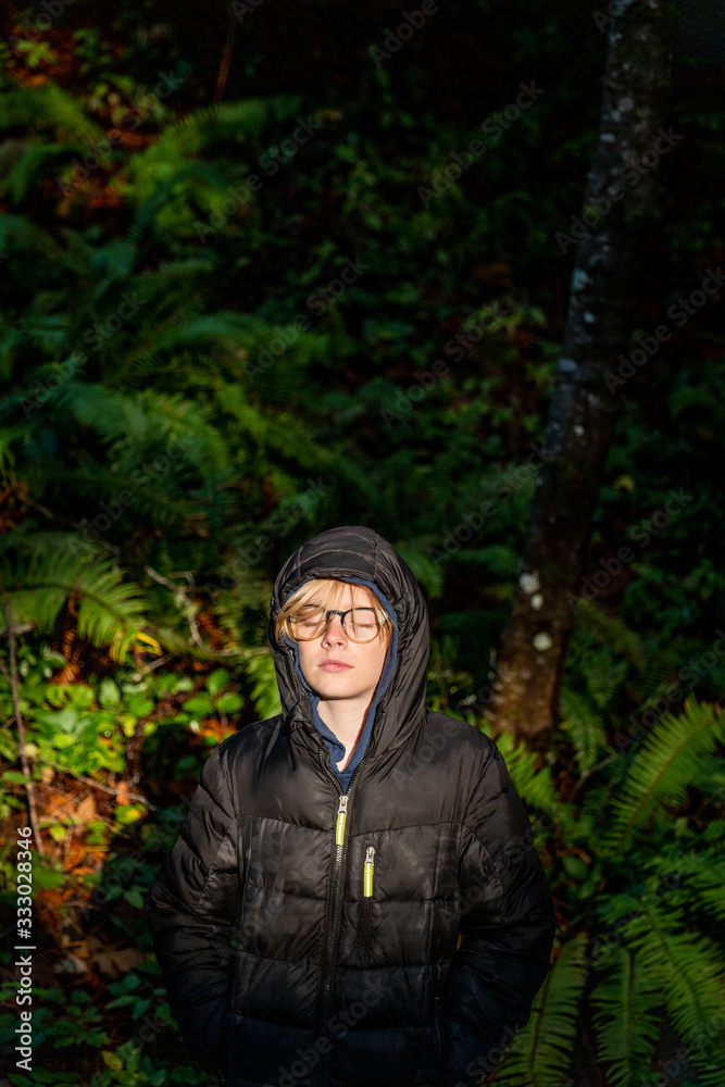 Portrait of tween boy standing in sunshine with eyes closed. Portrait of tween boy standing in sunshine with eyes closed.