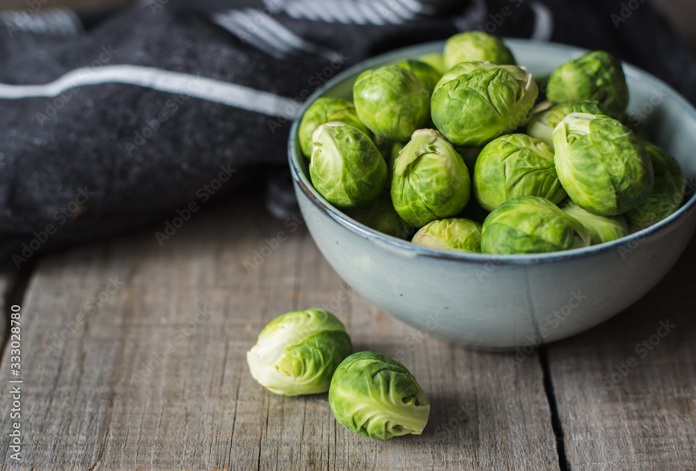 Bowl of Brussels sprouts and napkin on a rustic wooden table. Bowl of Brussels sprouts and napkin on a rustic wooden table.
