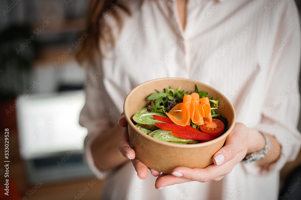 Woman holds a paper plate with food. Home delivery food. Healthy eating concept.