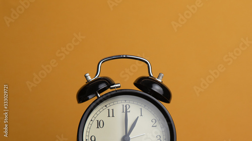 Alarm clock on yellow background