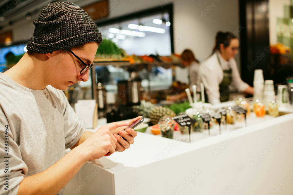 man hold the smartphone on shopping mall background man hold the smartphone on shopping mall background