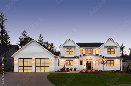 Beautiful modern farmhouse style luxury home exterior at twilight photo