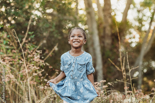 Close up portrait of happy preschool-aged confident girl smiling outsi photo