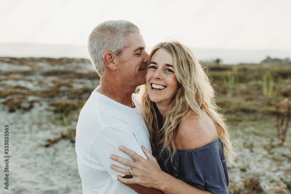 Married couple embracing at beach during sunset Married couple embracing at beach during sunset