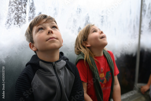 Two children looking up with wonder at waves and water
