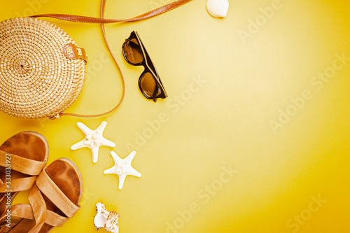 Eco friendly wicker Straw bag over yellow background with space for text, top view, wide composition. Summer vacation fashion, holiday concept.