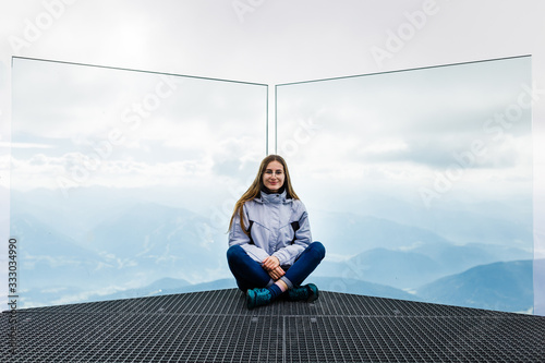 young girl enjoys the views of the Alps from the observation deck photo