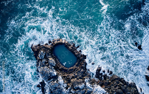 Waves crashing over rocks in sea photo