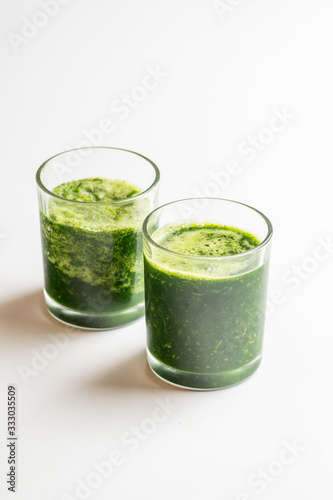 two glasses of green spinach smoothie. Vegan and raw food cocktail