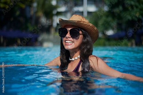 Stylish trendy young teen visco girl wearing a straw hat and necklace photo