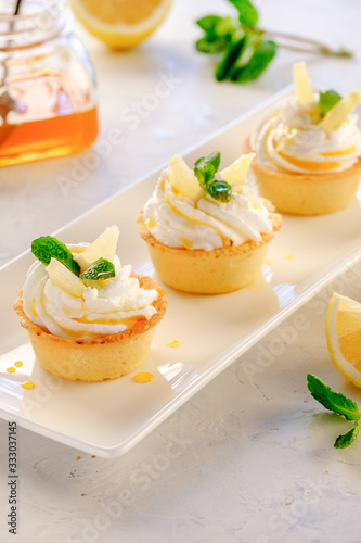 Tartlets with lemon kurd and italian meringue on a white plate