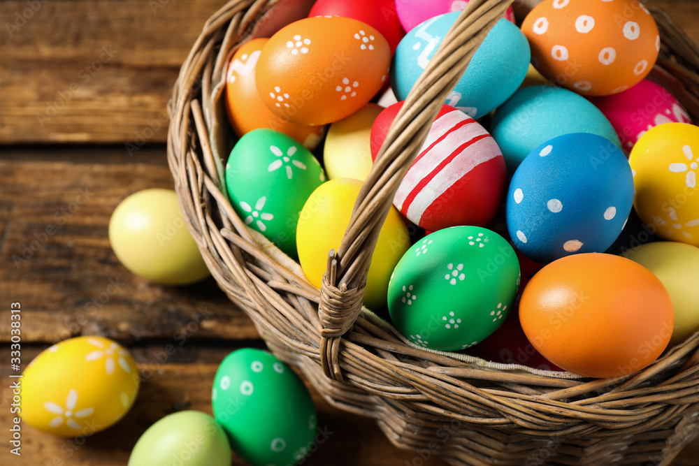 Colorful Easter eggs in basket on wooden background, closeup Colorful Easter eggs in basket on wooden background, closeup