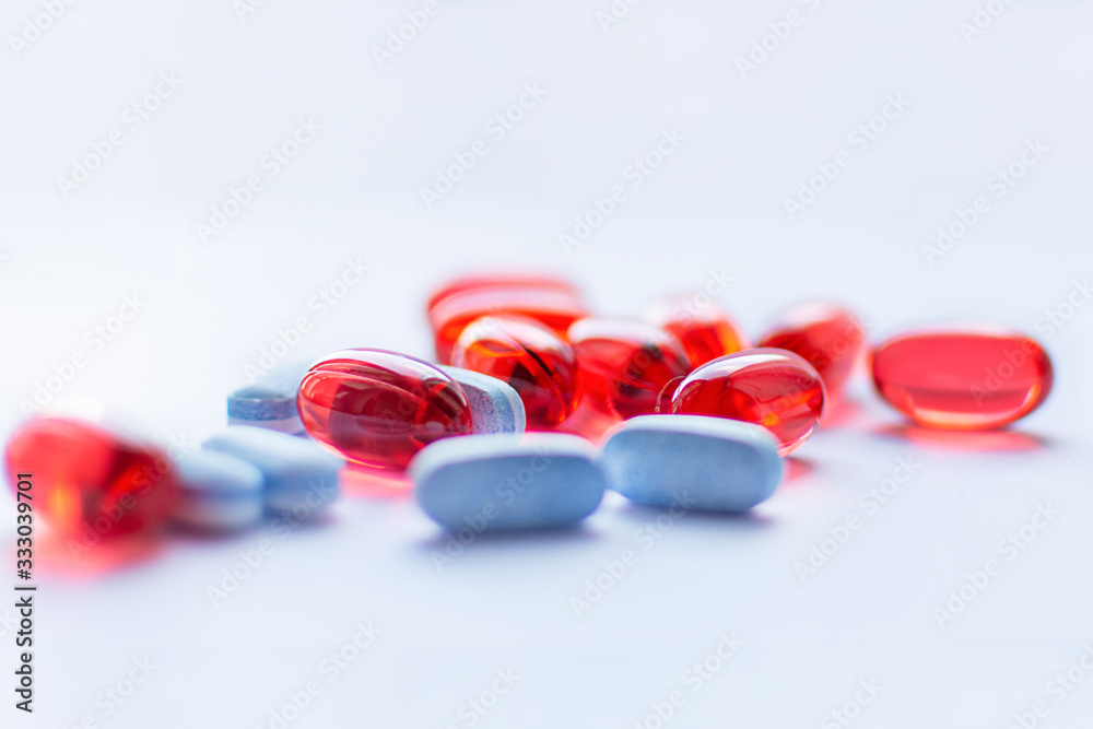 Red and blue capsules on white background. Traditional medicine treatment. Red and blue capsules on white background. Traditional medicine treatment.