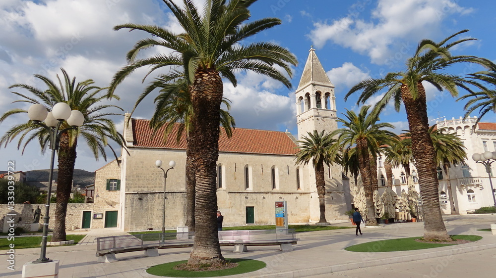 Church behind palm tree in Trogir Croatia