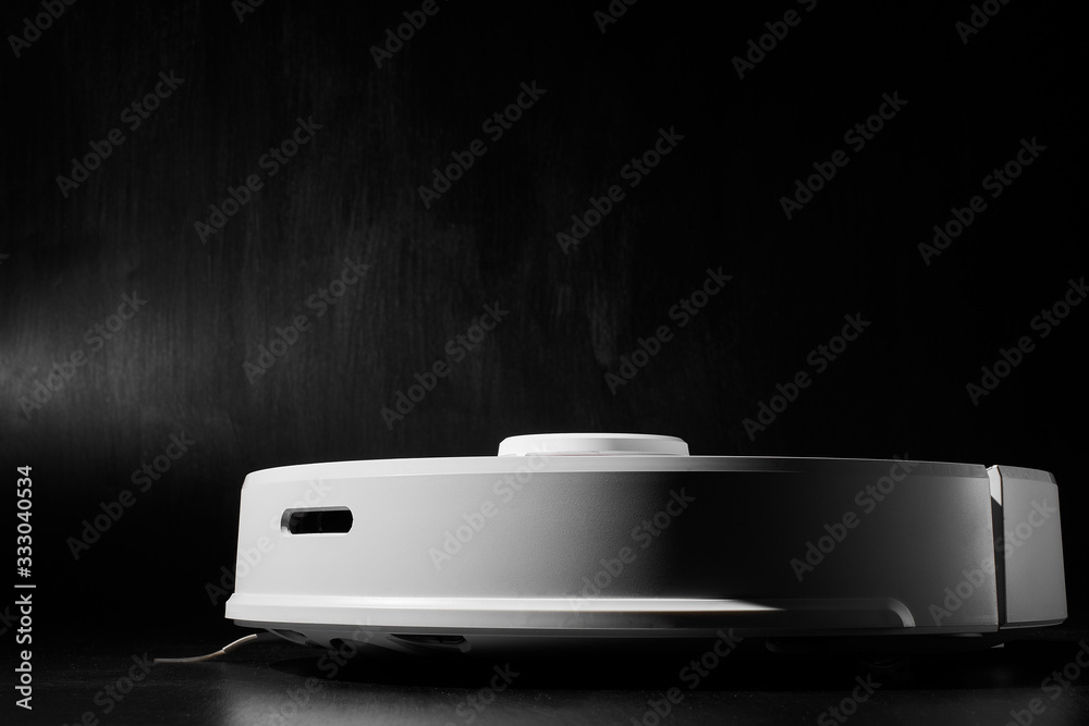 white Robotic vacuum cleaner on black background side view
