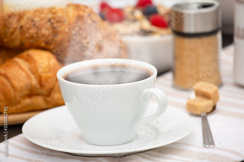 Fototapeta Naklejka Na Ścianę i Meble -  Breakfast Served in the morning with Hot black coffee and croissants Natural corn flake breakfast cereal in cups and fruit on the breakfast table every day