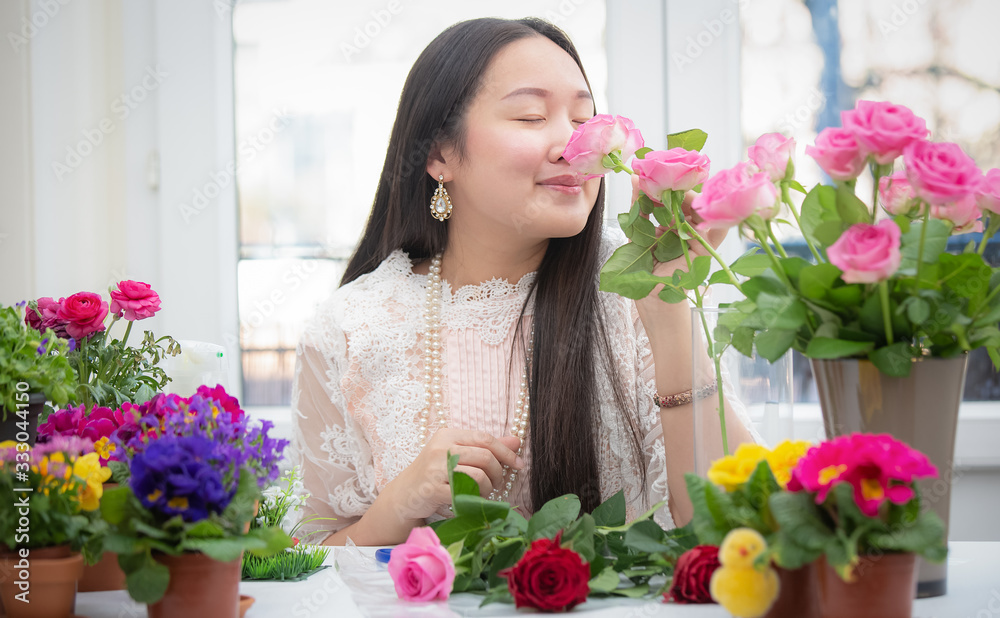 Woman Preparing to trim red and pink roses and beautiful flower arrangements in the home, flower arrangements with vase for gift-giving for Valentine's Day and Business in the family on the on table Woman Preparing to trim red and pink roses and beautiful flower arrangements in the home, flower arrangements with vase for gift-giving for Valentine's Day and Business in the family on the on table