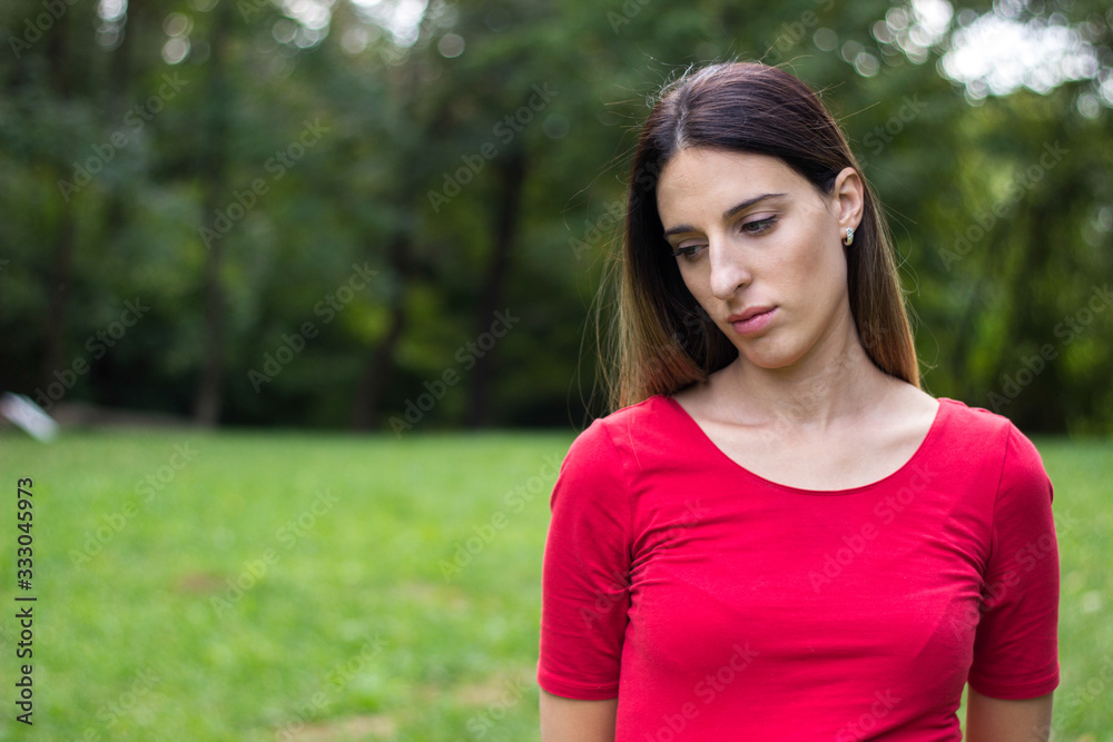 Woman looking thoughtful. Walking arround, outdoors, in the park Woman looking thoughtful. Walking arround, outdoors, in the park