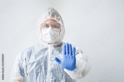 Photo of a doctor in a mask and overalls. Hand forward-stop viruses. 2019-nCoV. A man on an isolated background.