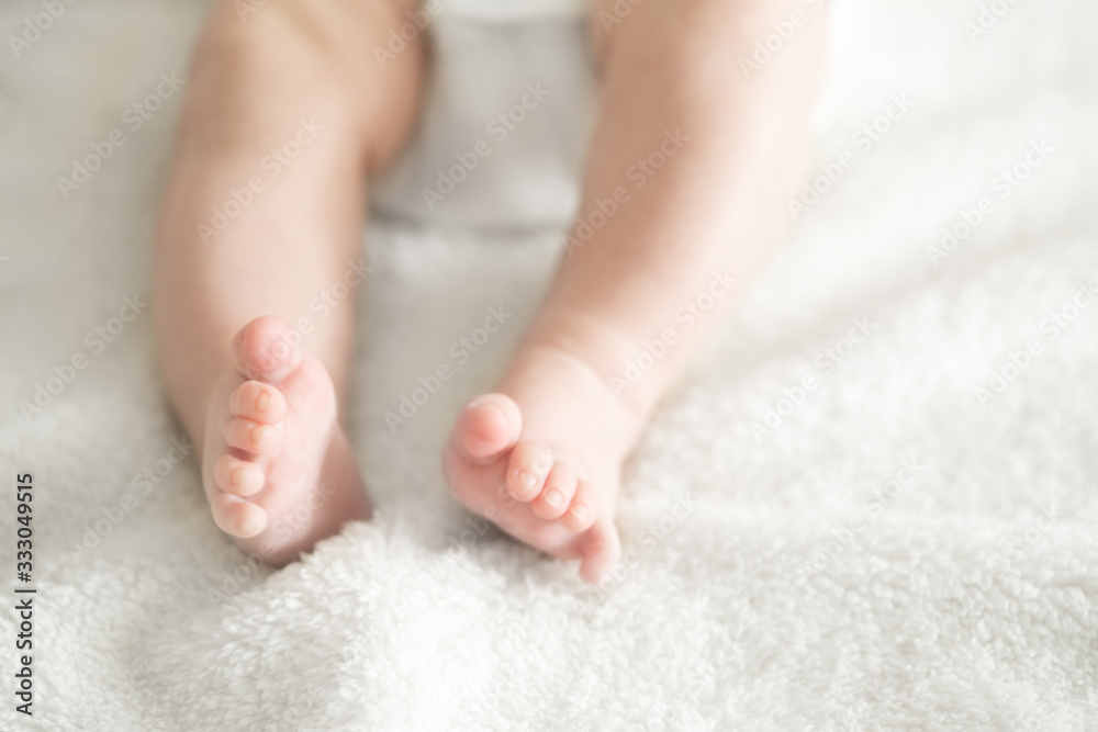 pair of baby newborn feet in a soft white blanket blurred pair of baby newborn feet in a soft white blanket blurred