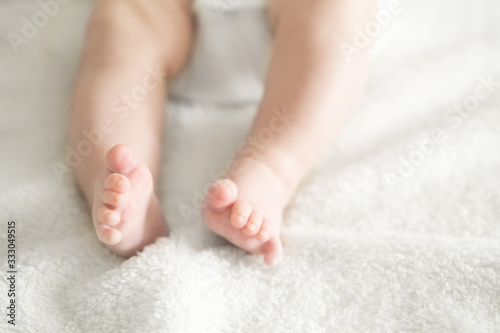 pair of baby newborn feet in a soft white blanket blurred