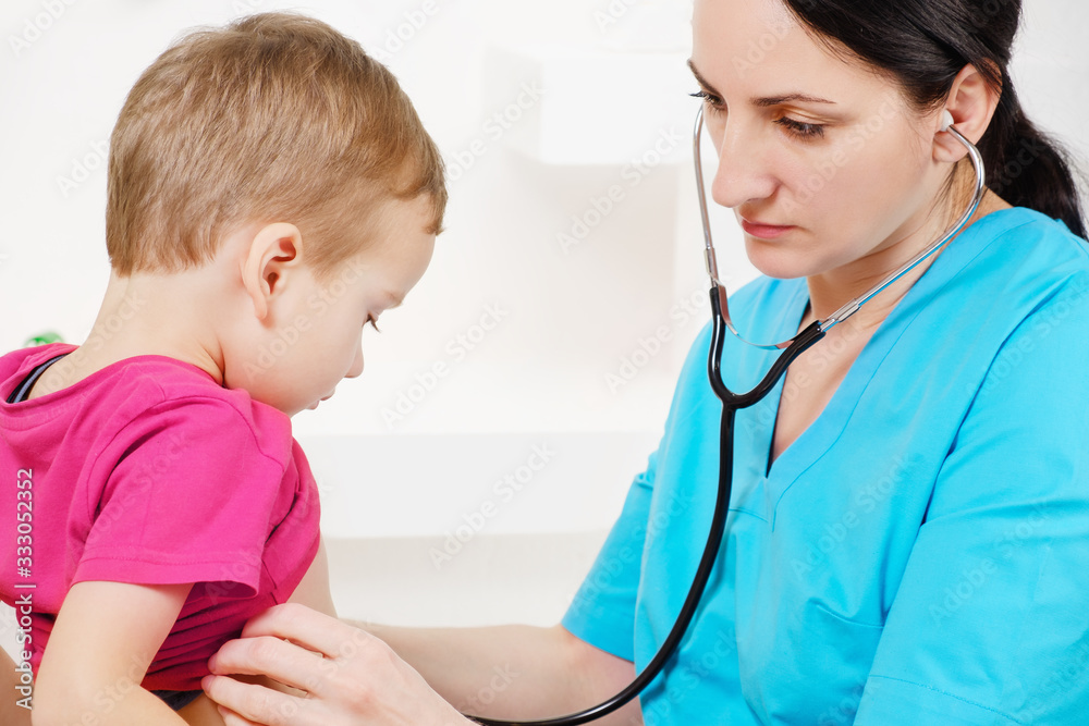 Doctor using stethoscope to examining little sweet boy Doctor using stethoscope to examining little sweet boy