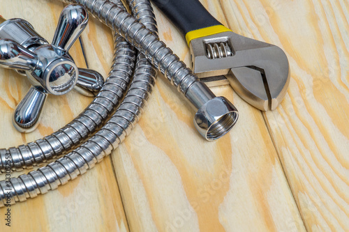 Plumbing materials, faucet, tool and hose on wooden boards are used to replace or repair