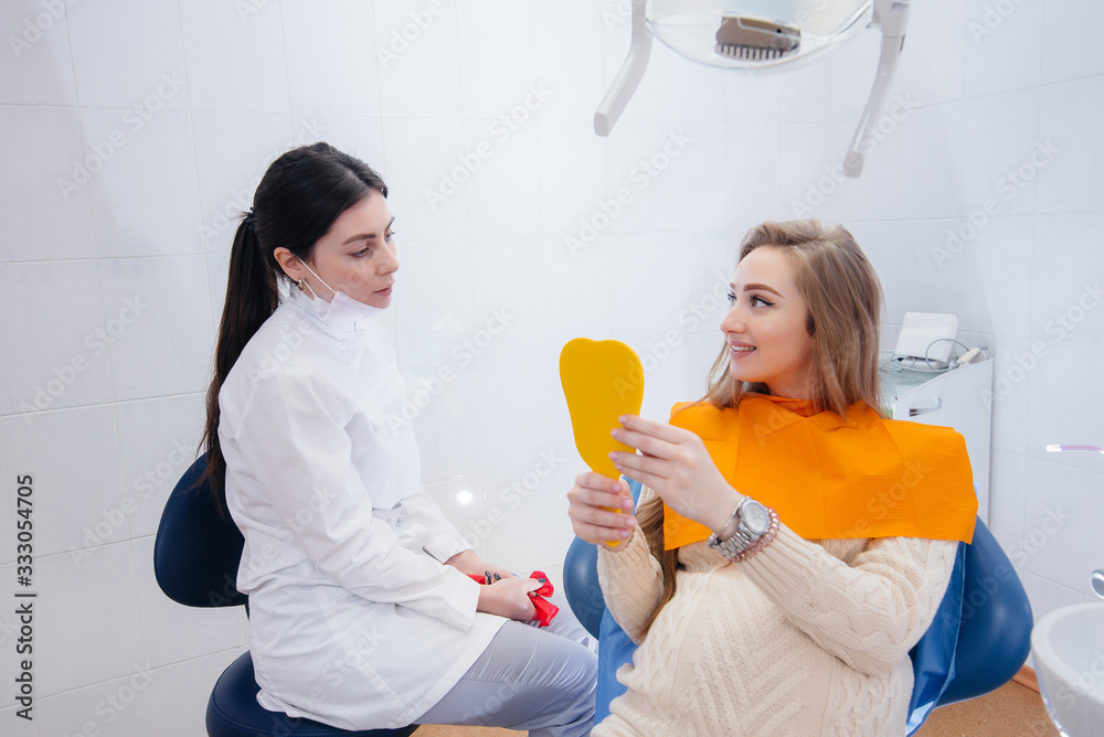 A professional dentist treats and examines the oral cavity of a pregnant girl in a modern dental office. Dentistry A professional dentist treats and examines the oral cavity of a pregnant girl in a modern dental office. Dentistry