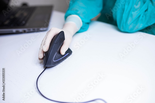 hand of a medical scientist in a medical glove uses a vertical ergonomic computer mouse-joystick. prevention carpal tunnel syndrome photo