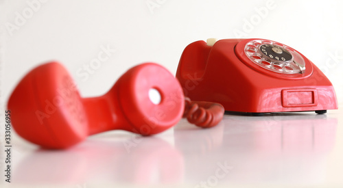 Retro red telephone with off-hook handset in front of us photo