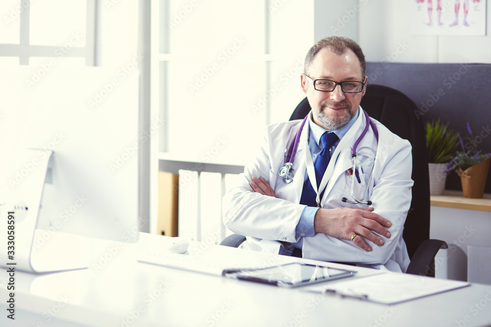 Portrait of senior doctor in office sitting at the desk Portrait of senior doctor in office sitting at the desk