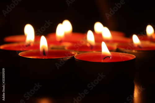Group of red candles burning in the dark