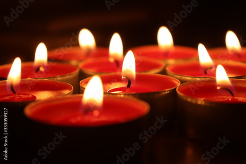 Group of red candles burning in the dark