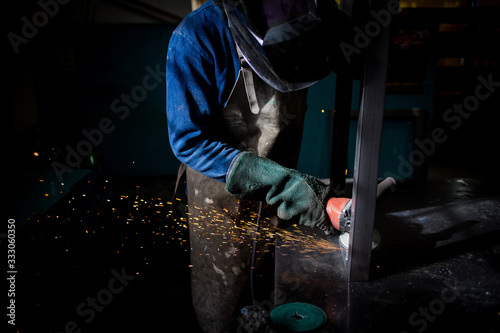 Close up image of an industrial worker working with an angle grinder
