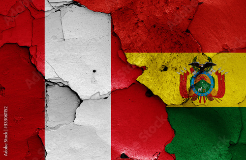 flags of Peru and Bolivia painted on cracked wall