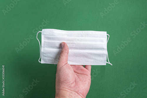 Man's hand holding surgical mask