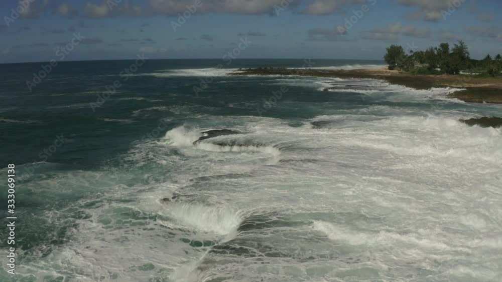 The rough waves of the Pacific Ocean crashing into the rocky coastline of Oahu in the Hawaiian Islands with the camera moving backwards. The rough waves of the Pacific Ocean crashing into the rocky coastline of Oahu in the Hawaiian Islands with the camera moving backwards.