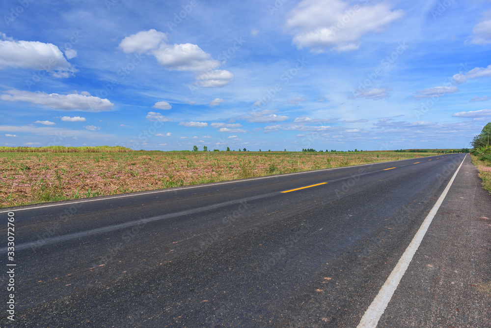 Asphalt road and landscape countryside with blue sky.