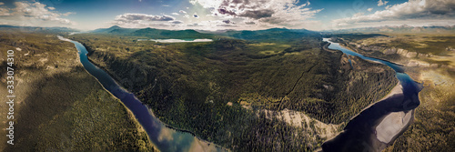 Drone aerial view of Yukon Territory wilderness with river running along the whole panoramic shot with panorama view of river outside Whitehorse. 
