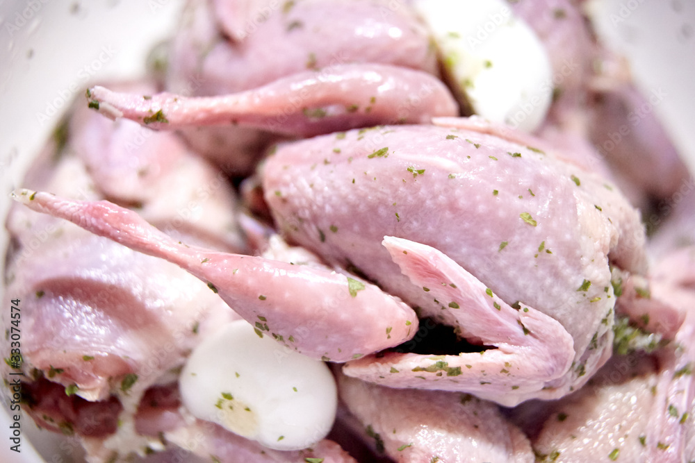 Naklejka premium Close up of raw quail with onions