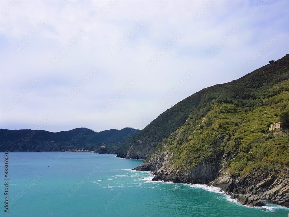 Italy, Cinque Terre, Vernazza. Beautiful view of a coast line with greenery, turquoise sea and rocks