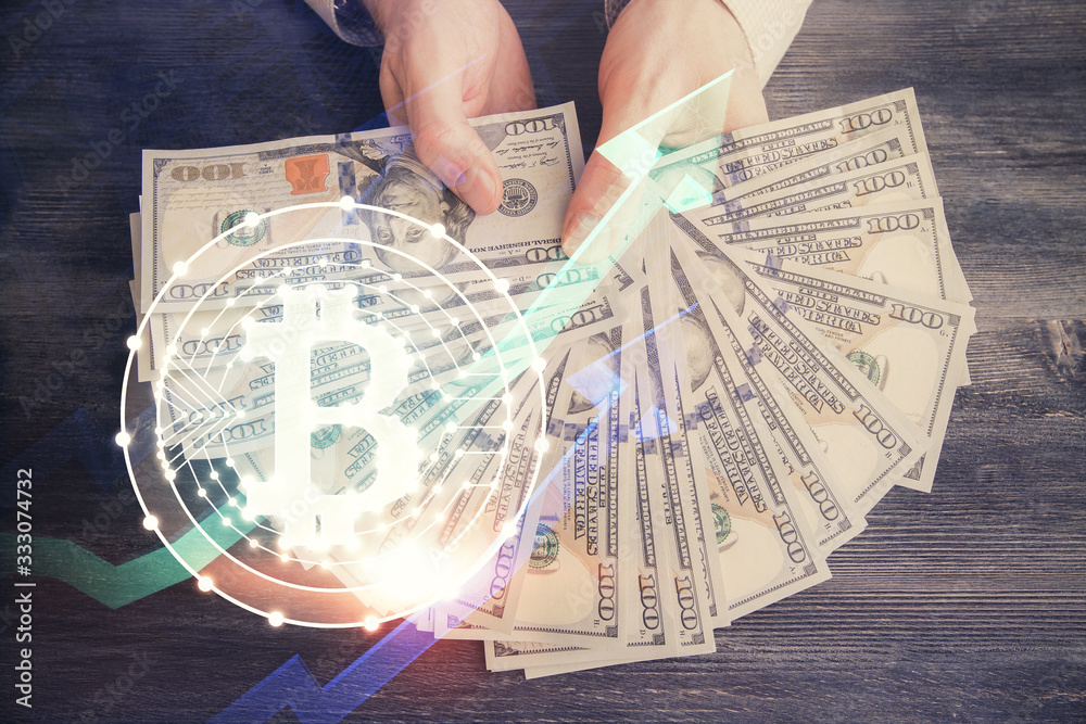 Multi exposure of blockchain theme drawing hologram and USA dollars bills and man hands. Business concept. Multi exposure of blockchain theme drawing hologram and USA dollars bills and man hands. Business concept.