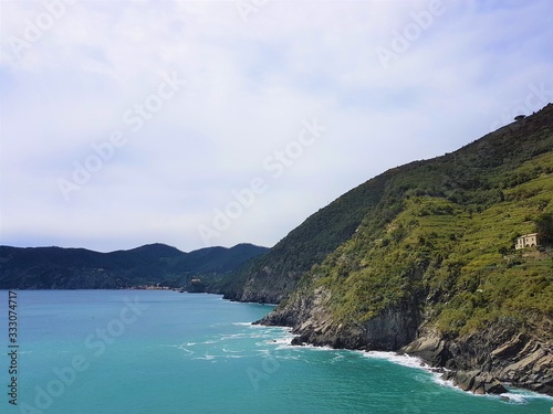 Italy, Cinque Terre, Vernazza. Beautiful view of a coast line with greenery, turquoise sea and rocks